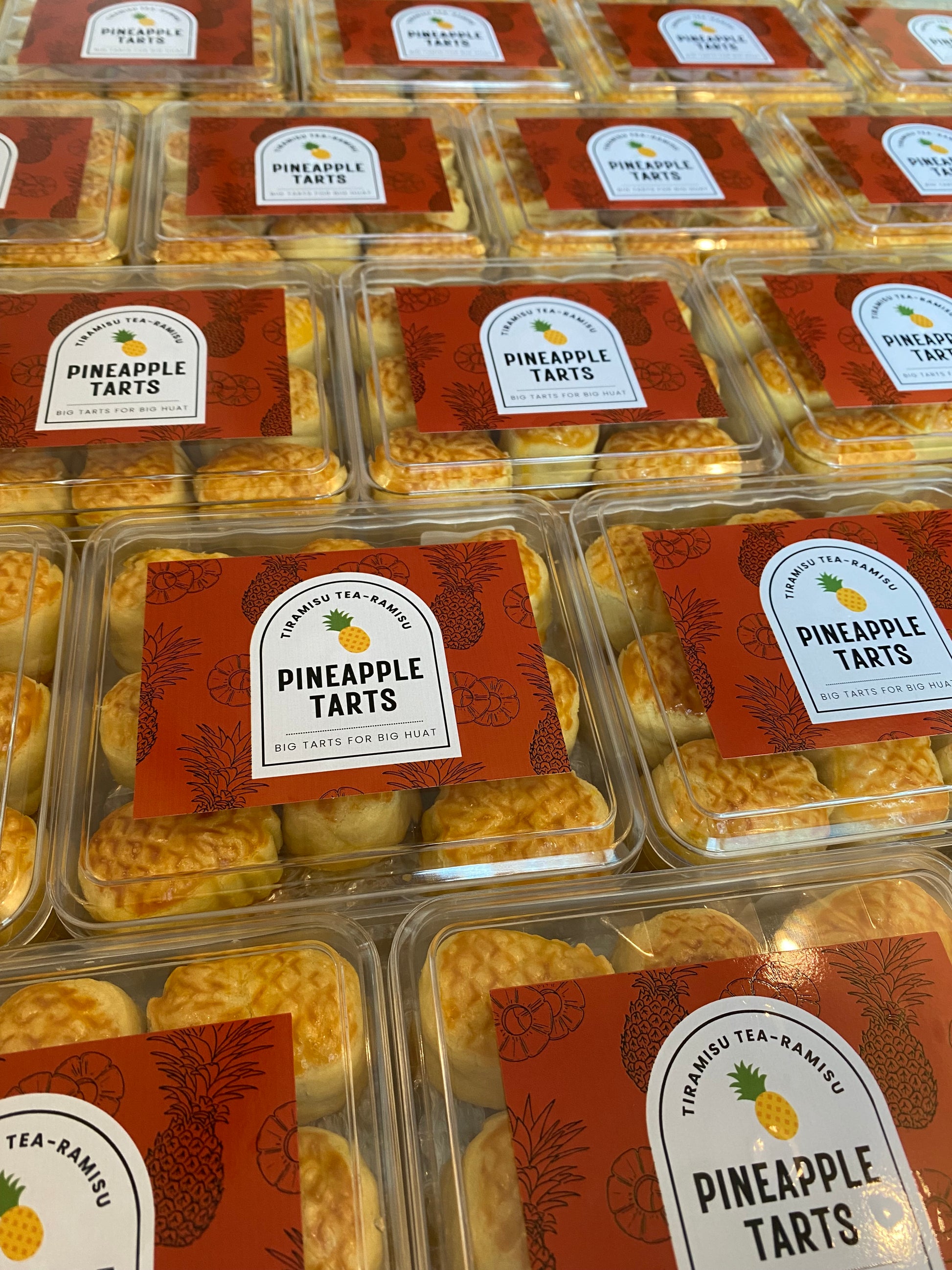 Packaged pineapple tarts with visible labels on a reflective surface