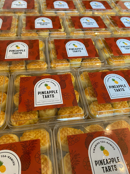 Packaged pineapple tarts with visible labels on a reflective surface