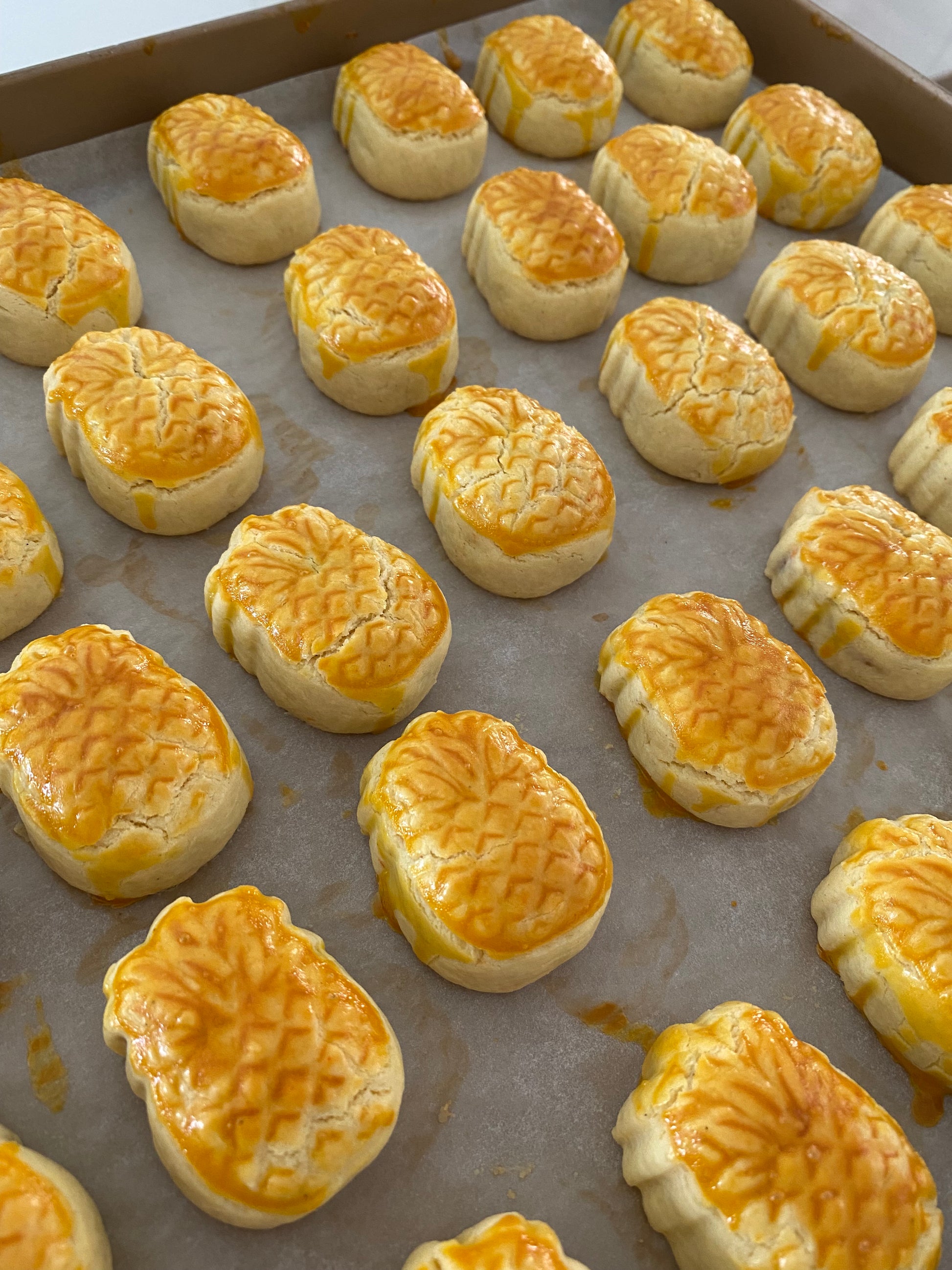 Baked Pineapple tarts with a golden brown crust on a baking tray.