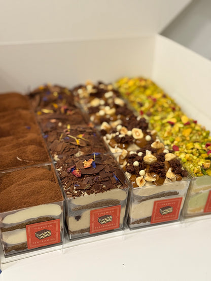 Assorted Tiramisus in clear packaging with visible branding on a white surface.