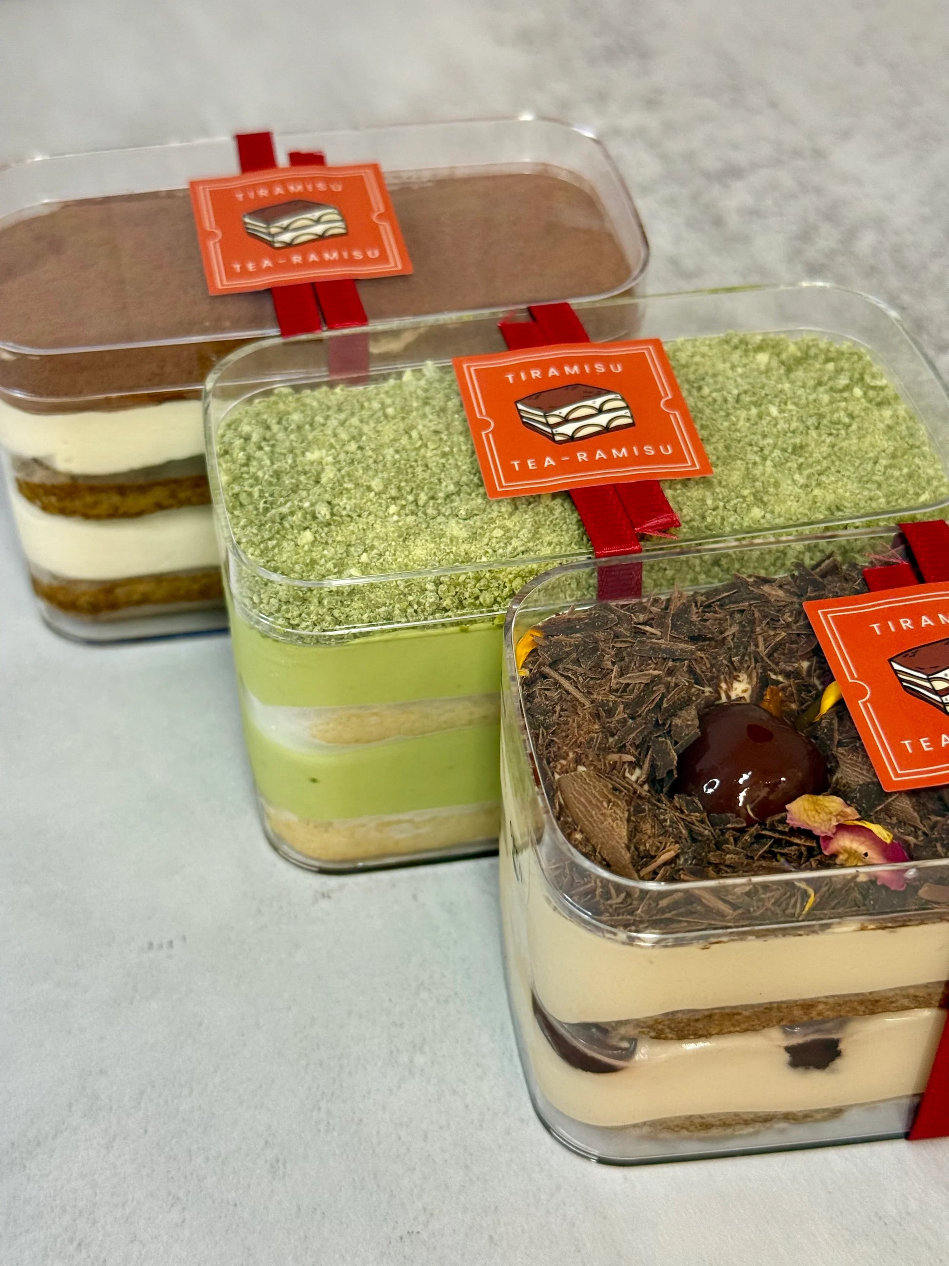 Assorted flavours of Tiramisu in mini tubs. Flavours include Classic, Matcha and Oolong